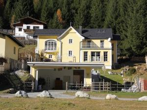 ein großes gelbes Haus auf einem Hügel in der Unterkunft Villa Marie-Sophie by Interhome in Mallnitz