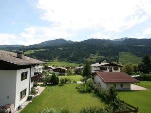 a house with a large yard with mountains in the background at Apartment Haus Viktoria by Interhome in Fürstau