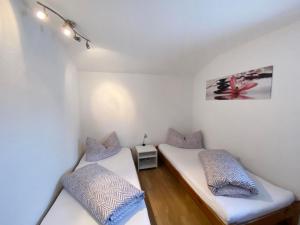 2 łóżka w pokoju z białymi ścianami i niebieskimi poduszkami w obiekcie Apartment Margret - LFD125 by Interhome w Langenfeld