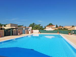 a large blue swimming pool in a yard at Holiday Home Le Hameau des Capellans by Interhome in Saint-Cyprien-Plage