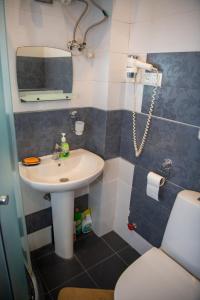een badkamer met een wastafel, een toilet en een spiegel bij Very City Center Studio Apt in Tbilisi City
