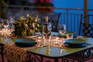 a table with a bottle of wine and glasses on it at Villa Eris Amalfi Coast in Conca dei Marini