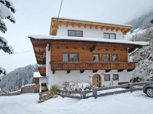 a house in the snow with a car parked in front at Apartment Silvia - MHO357 by Interhome in Brandberg