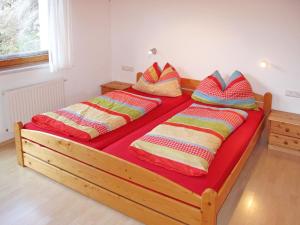 two beds with colorful pillows on them in a room at Apartment Silvia - MHO357 by Interhome in Brandberg