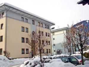 un edificio cubierto de nieve con un coche aparcado delante en Apartment Haus Kitzsteinhorn by Interhome en Zell am See