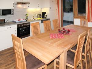 een keuken met een houten tafel met stoelen eromheen bij Apartment Edelweiss - MHO527 by Interhome in Ramsau im Zillertal