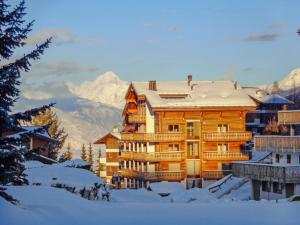 a large wooden building with snow on the roof at Apartment Les Cimes Blanches 102 A by Interhome in Nendaz