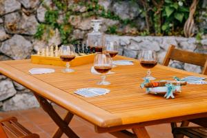 a wooden table with glasses of wine and a chessboard at Villa Eris Amalfi Coast in Conca dei Marini