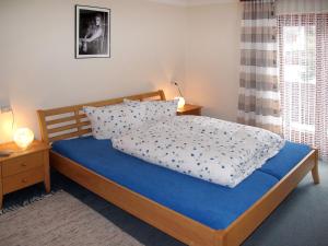 una camera da letto con un letto con una coperta blu e cuscini di Apartment Babsi by Interhome a Ginzling
