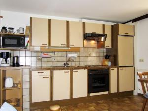 uma cozinha com armários brancos e um forno preto em Apartment Haflingerhof Enzian - KNT100 by Interhome em Kaunertal