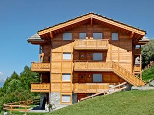 Una gran casa de madera con balcones en una colina en Apartment La Corniche 2 by Interhome, en Nendaz