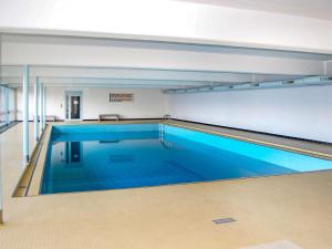une piscine à l'eau bleue dans un immeuble dans l'établissement Apartment Derborence 25 by Interhome, à Nendaz