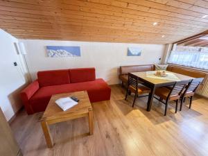 ein Wohnzimmer mit einem roten Sofa und einem Tisch in der Unterkunft Apartment Apart Grazia - PTZ150 by Interhome in Prutz