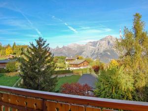 d'un balcon avec vue sur une maison et les montagnes. dans l'établissement Apartment Les Cimes Blanches B 401 by Interhome, à Nendaz