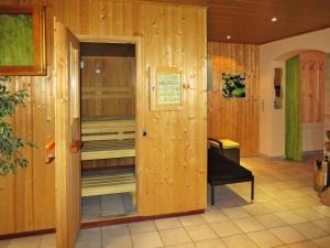Cette chambre dispose de murs en bois et d'une console de visualisation. dans l'établissement Apartment Daheim – Bergliebe - PZT381 by Interhome, à Plangeross