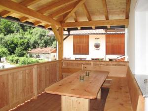eine Holzterrasse mit einem großen Holztisch in der Unterkunft Holiday Home Aster - RID400 by Interhome in Tösens
