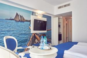 a hotel room with a television and a painting on the wall at Continental Forum Constanta in Constanţa