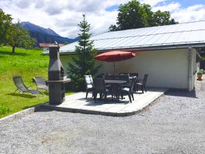 eine Terrasse mit einem Tisch, Stühlen und einem Sonnenschirm in der Unterkunft Chalet Jagdhaus Biedenegg - FIE215 by Interhome in Fliess