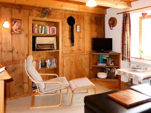 a living room with wooden walls and a tv and chairs at Holiday Home Hackenschmiede - PTZ130 by Interhome in Prutz