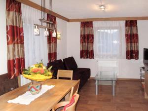 ein Wohnzimmer mit einem Sofa und einem Tisch in der Unterkunft Apartment Alpenherz - PTZ431 by Interhome in Fendels