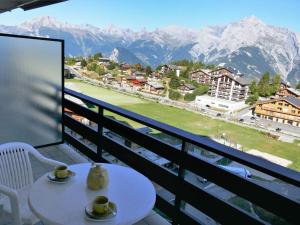 a balcony with a table and a view of the mountains at Apartment Christiania 2 O3 by Interhome in Nendaz