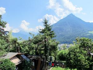 una montagna in lontananza con una casa e un albero di Apartment Anich by Interhome a Imst