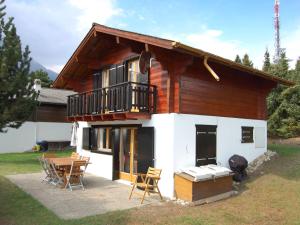 a house with a balcony and a table and chairs at Chalet Coucordin by Interhome in Nendaz