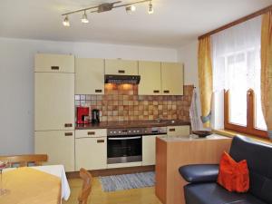 una cucina con armadi bianchi e un divano in camera di Apartment Tyrol - TDL125 by Interhome a Tobadill