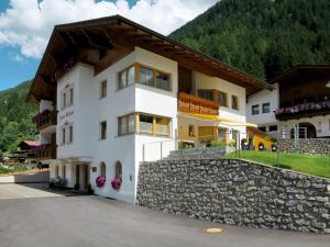 ein Haus in den Bergen mit einer Steinmauer in der Unterkunft Apartment Elfriede - SZU123 by Interhome in See