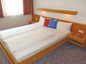 a bedroom with a large white bed with two pillows at Apartment Elfriede-3 by Interhome in See