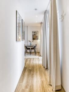 a hallway with white walls and a dining room with a table at limehome Essen Kibbelstraße in Essen