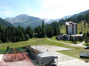 a building in a field with mountains in the background at Apartment Rosablanche C22 by Interhome in Siviez