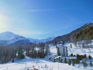 a ski lodge in the snow with mountains in the background at Apartment Rosablanche D32 by Interhome in Siviez