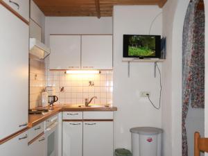 カップルにあるApartment Maria - KPL580 by Interhomeの白いキャビネットと壁掛けテレビ付きのキッチン