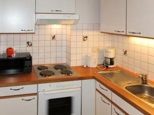 a kitchen with a stove top oven next to a sink at Apartment Maria by Interhome in Kappl