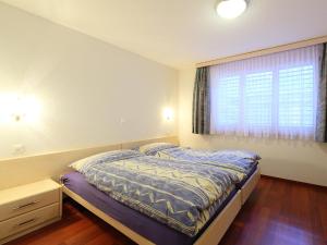 ein kleines Schlafzimmer mit einem Bett und einem Fenster in der Unterkunft Apartment Roger-2 by Interhome in Zermatt