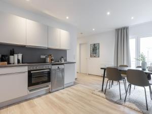 a kitchen and dining room with a table and chairs at limehome Essen Kibbelstraße in Essen