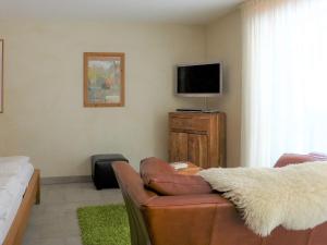ein Wohnzimmer mit einem Sofa und einem Flachbild-TV in der Unterkunft Apartment Rütschi-3 by Interhome in Zermatt