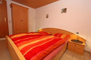 クラーコー・アム・ゼーにあるFerienhaus Krakow am See SEE 4001のベッドルーム1室(赤とオレンジの毛布付きのベッド1台付)