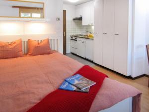 Un dormitorio con una cama con un libro. en Apartment Sungold-1 by Interhome en Zermatt