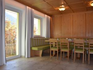 jadalnia ze stołem i krzesłami oraz oknem w obiekcie Apartment Schranz - KPL520 by Interhome w mieście Kappl