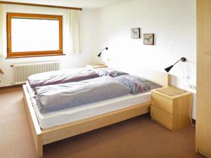 a bedroom with a bed and a window and a lamp at Holiday Home Julia by Interhome in Kappl