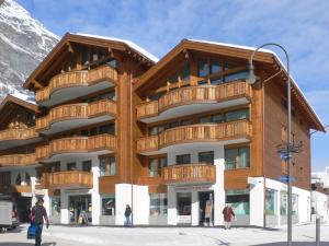 un gran edificio con gente caminando delante de él en Apartment Zur Matte B-4 by Interhome, en Zermatt