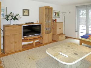 a living room with a flat screen tv and wooden cabinets at Apartment Dobler - LNR110 by Interhome in Lorüns