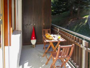 um alpendre com um chapéu de Pai Natal, uma mesa e cadeiras em Apartment Sungold-2 by Interhome em Zermatt