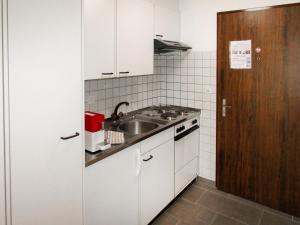 ツェルマットにあるApartment Sungold-2 by Interhomeの小さなキッチン(白いキャビネット、シンク付)