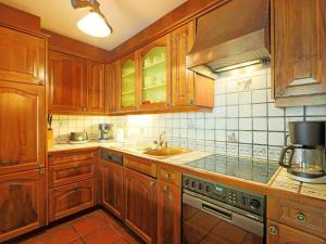 a kitchen with wooden cabinets and a sink at Apartment Bodmen A by Interhome in Zermatt