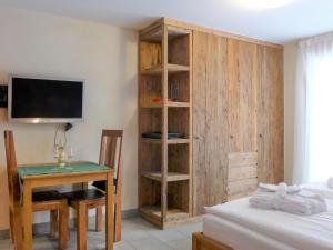 Pokój z biurkiem i telewizorem oraz sypialnią w obiekcie Apartment Rütschi-1 by Interhome w mieście Zermatt