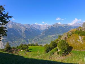 a fence on a hill with mountains in the background at Chalet Peer Gynt by Interhome in Nendaz