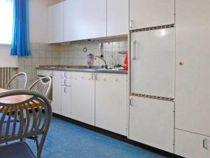 a kitchen with white cabinets and a refrigerator at Apartment Dianthus-1 by Interhome in Zermatt